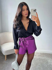 Deze Femke short met strik is ideaal voor een avondje uit. Gemaakt van glinsterend (kreukel)materiaal, met een hoge taille en een stijlvolle overslag met strik voor een chique uitstraling.