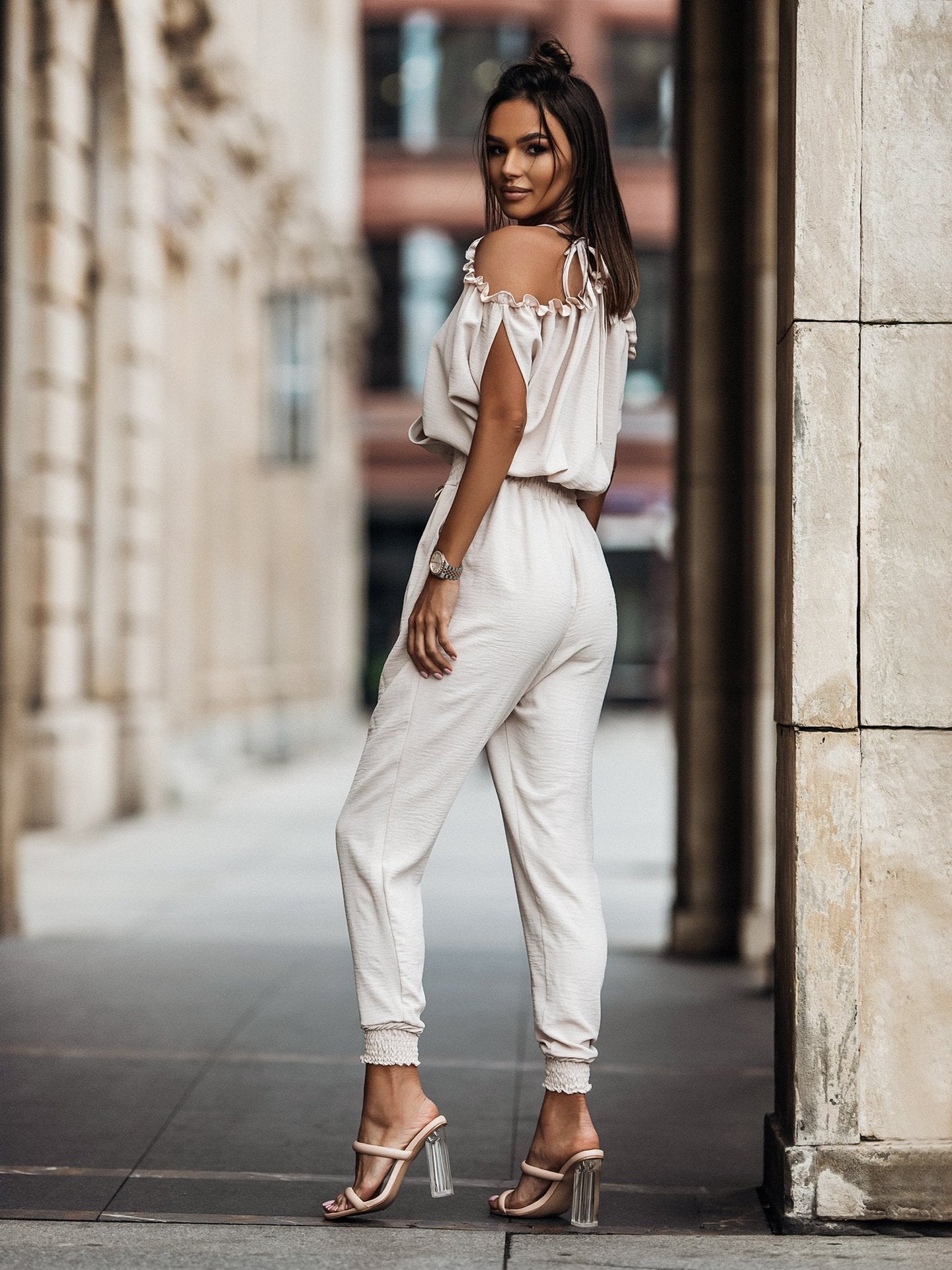 Witte jumpsuit met trendy open schouders, elegante overslag, v-hals en comfortabele elastische taille voor een veelzijdige en modieuze look, geschikt voor diverse gelegenheden.