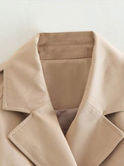 Beige cropped trenchcoat - een must-have voor een stijlvolle look. Voorzien van een double-breasted sluiting, kraag en verstelbare mouwen met manchetten voor een trendy uitstraling. Voeg moeiteloos een vleugje elegantie en professionele flair toe aan elke outfit.