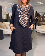 Elegante effen jurk in de kleur Zwart voor dames in stijl ideaal voor de herfst.