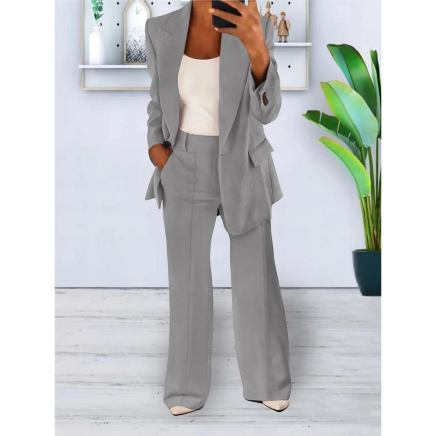 Damespak bestaande uit een stijlvolle blazer en bijpassende broek. Met een losse fit, effen kleur en praktische casual zakken. Perfect voor diverse gelegenheden en eenvoudig te combineren voor verschillende looks.