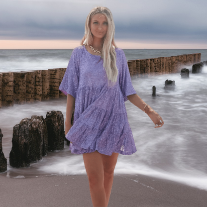 Glinsterende babydoll-casual jurk met lichte en zwierige snit voor bewegingsvrijheid en comfort. Deze jurk is voorzien van korte mouwen, stijlvolle details en is veelzijdig te combineren voor zowel een casual als glamoureuze uitstraling.