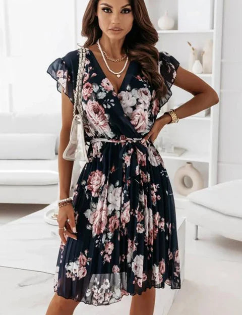Stijlvolle jurk met diepe V-hals en geplooid ontwerp voor een extra dimensie. Wikkelstijl, knielengte en modieuze bloemenprint voor een trendy look. Gemaakt van ademende stof voor comfort. Pas de plooien aan voor een perfecte pasvorm en een nette uitstraling.