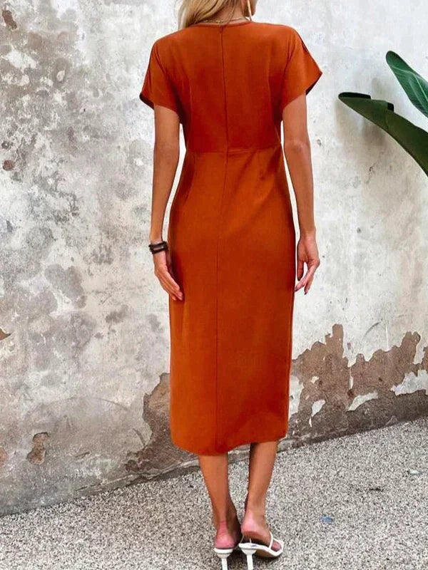 Fleur midi-jurk in zonnig oranje, compleet met een trendy V-hals voor een modieuze look. Gemaakt van hoogwaardige materialen voor ultiem comfort en veelzijdigheid.