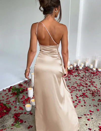 Maxi jurk gemaakt van luxe satijnen stof met stretch voor een perfecte pasvorm. Voorzien van gedrapeerde details, eenzijdige schouder en een elegante dij-hoge split.