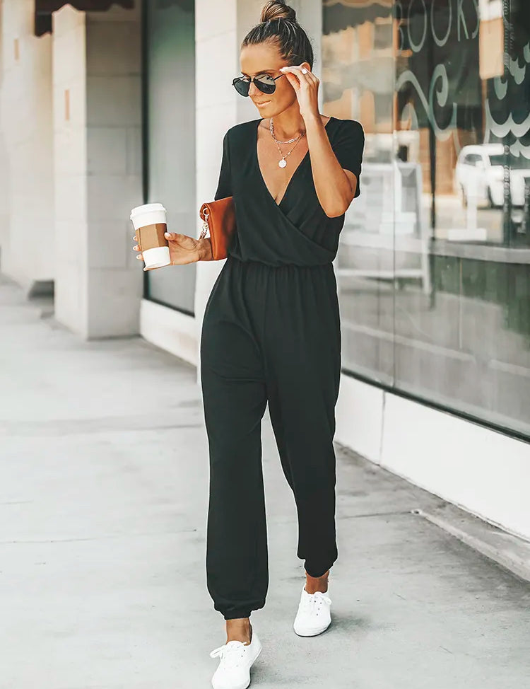 Stijlvolle zwarte jumpsuit met korte mouwen, v-hals en elastische taille voor een trendy uitstraling en comfortabele pasvorm. Gemaakt van polyester en spandex voor een soepele en mooie val over het lichaam. Een must-have voor diverse gelegenheden.