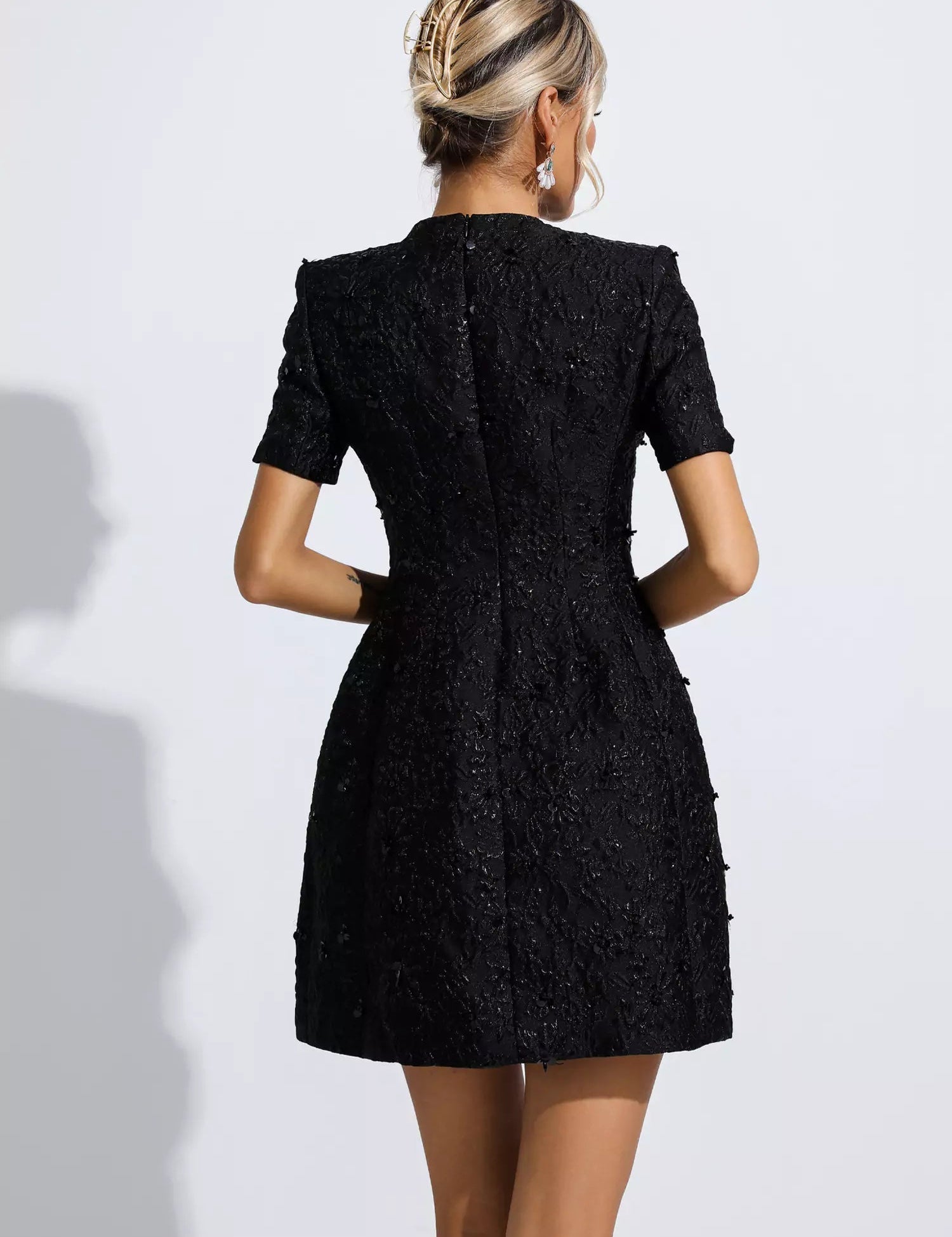 Deze zwarte jacquard bloemenjurk belichaamt ultieme vrouwelijkheid en betovert met een prachtig bloemenpatroon. Geschikt voor elke gelegenheid accentueert deze jurk op elegante wijze het silhouet en de charme.