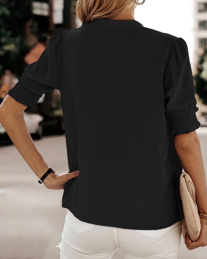 Blouse met een stijlvolle V-hals en trendy korte mouwen. Een veelzijdige aanvulling op je garderobe met een perfecte balans tussen casual en professioneel. Gemaakt van luchtige chiffon en duurzaam polyester voor comfort en stijl. Voorzien van een flatterende V-hals, pofmouwen en een losse pasvorm voor bewegingsvrijheid. Maattabel beschikbaar voor borst, lengte en mouwen.